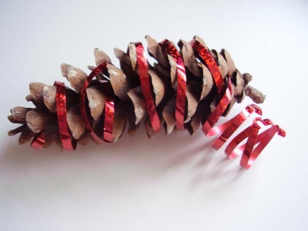 Kids Christmas craft with pine cone and ribbon