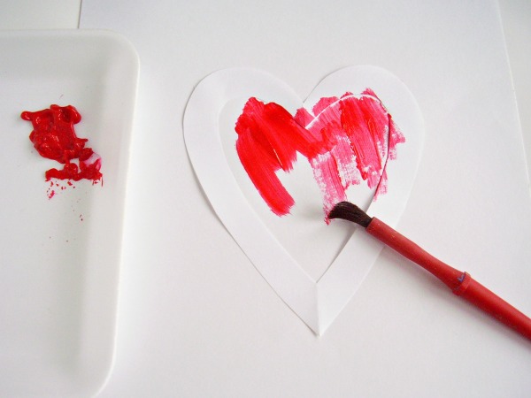 Place the stencil on white paper to make a heart painting