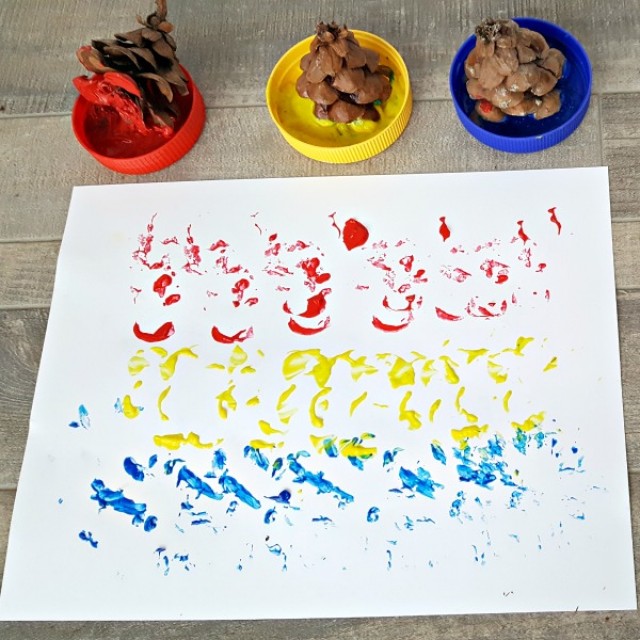 Kids process art painting activity with pine cone tops