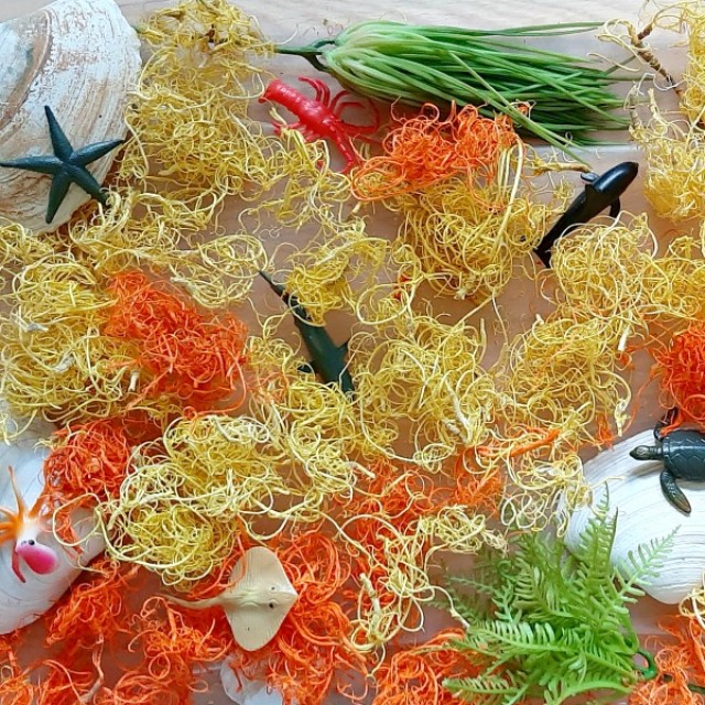 Kids sensory bin with curly moss and mini ocean animals