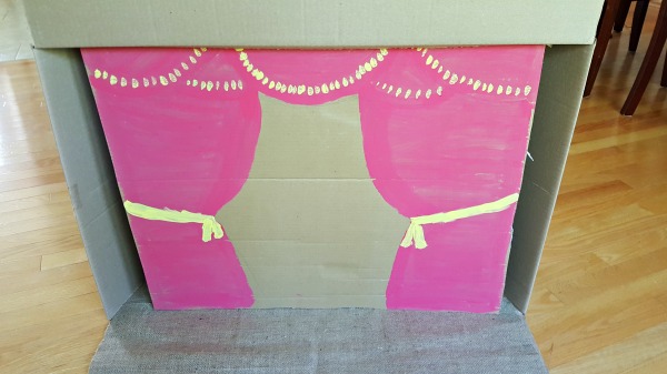 Paint a curtain design on cardboard for the diy marionette theater