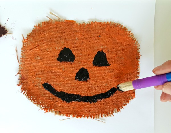 Paint eyes nose and mouth on the burlap pumpkin