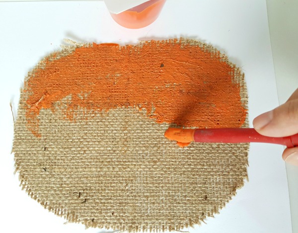 Paint the pumpkin shape cut from the burlap with orange craft paint