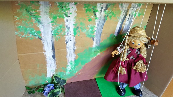 Puppet show with marionette in a cardboard box theater you can easily make.