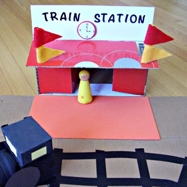 Small world play with a homemade cardboard box train station