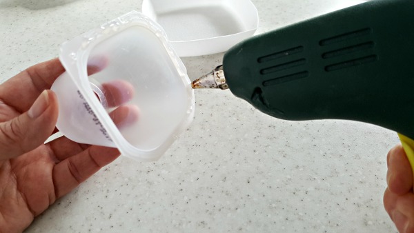 apply glue to yogurt cup with glue gun for science experiment