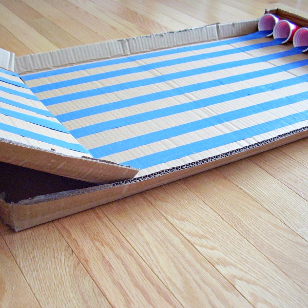 Cardboard inclined plane with marbles and recycled cups