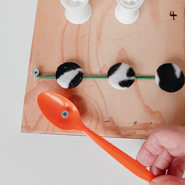 Attach small items to a board for fine motor activity