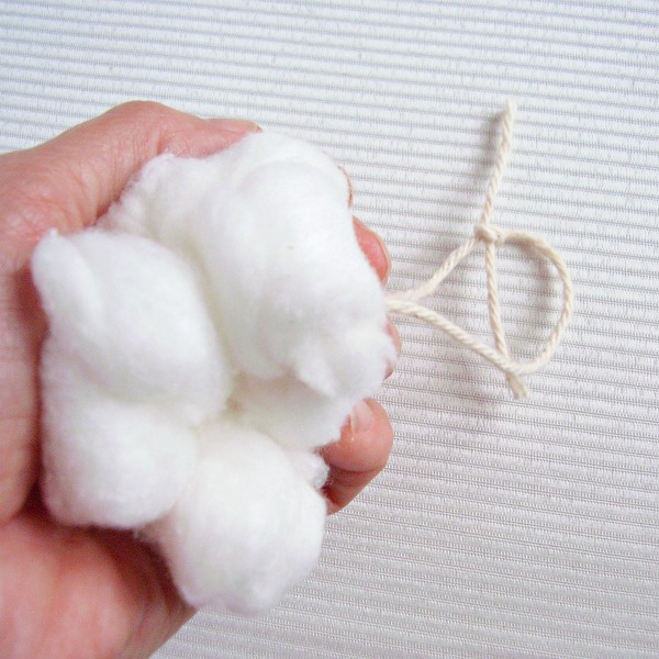 Scrunch the cotton ball ornament in your hands to shape the snowball