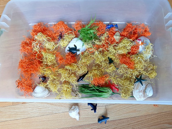 Artificial seaweed in a plastic bin for kids sensory play