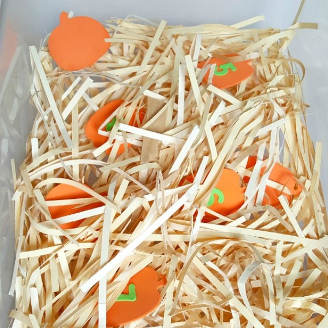 Fall sensory bin with foam pumpkins and shredded paper