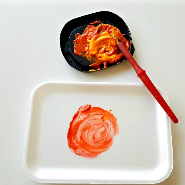 Paint pumpkins on foam trays in a kids art activity