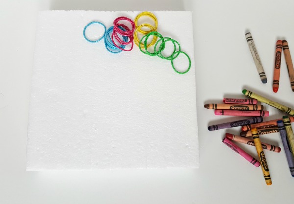 Foam base with crayons and elastics for geoboard