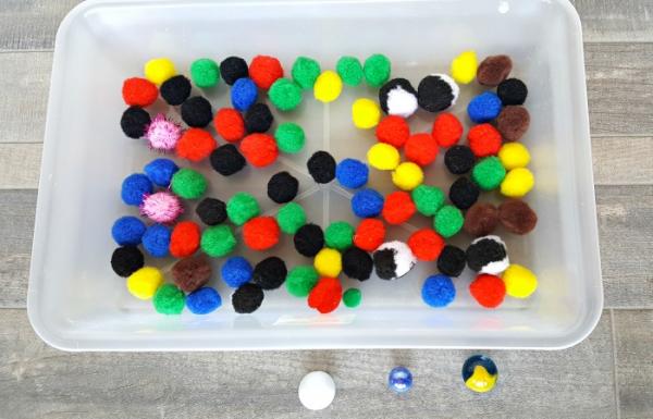 marble rolling through pompoms preschool activity