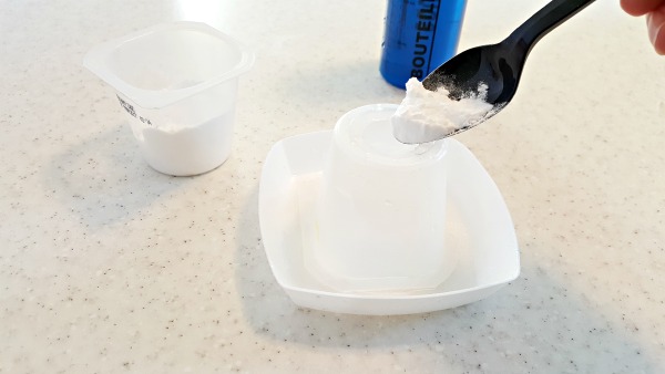 spoon soda into the hole at the top of the yogurt dish