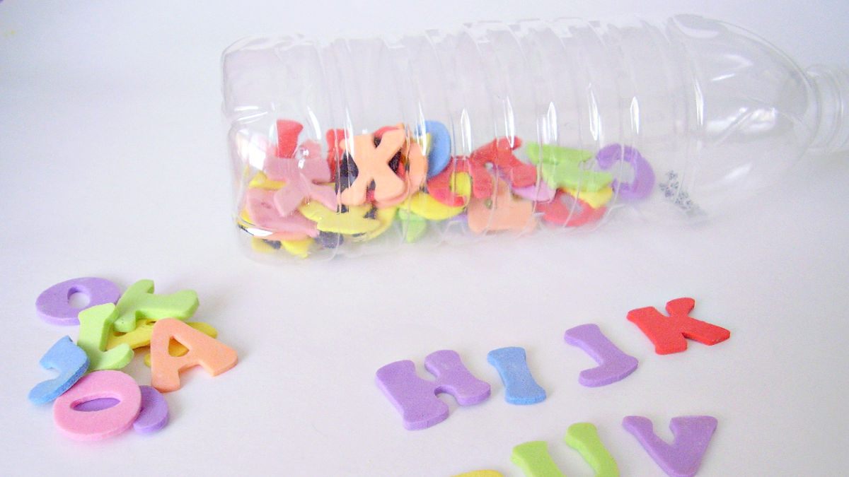 preschool literacy activity with foam letters in a recycled water bottle