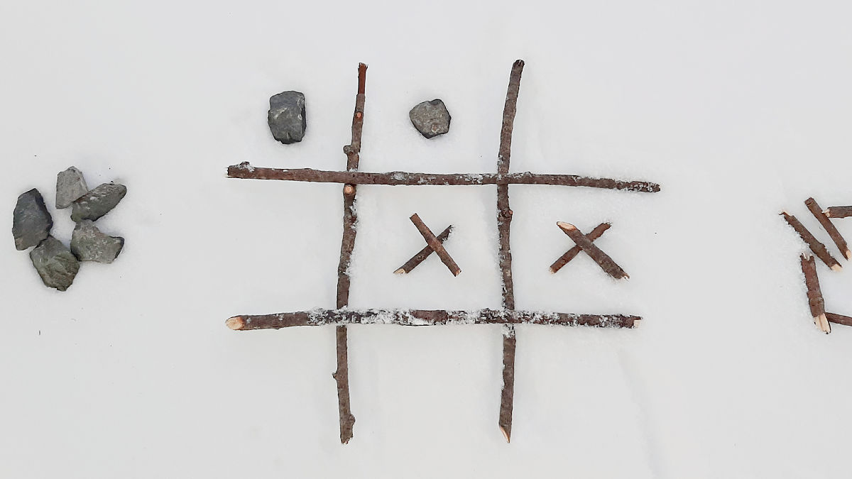 snow games outside with natural materials like twigs and stones