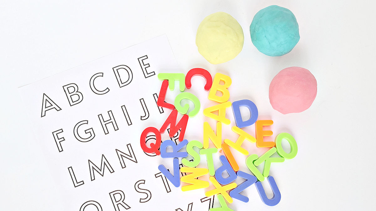 kids literacy activity with play dough and magnetic letters