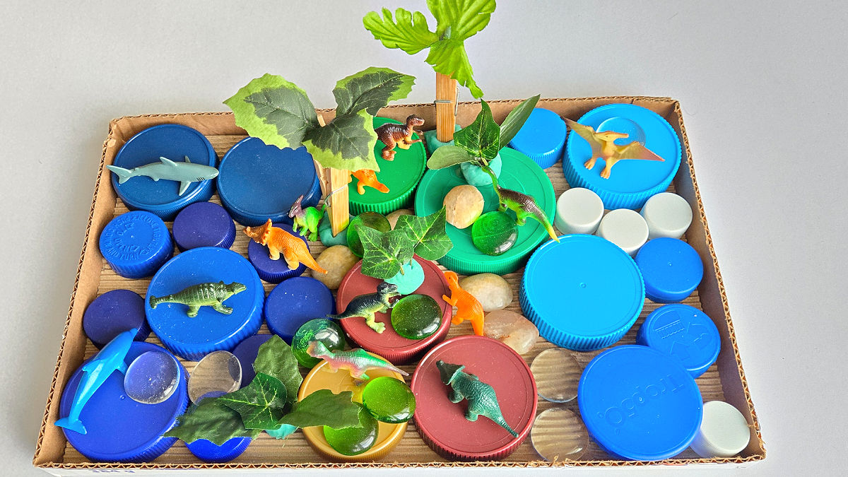 use jar lids to create a small world habitat for dinosaurs in a cardboard box