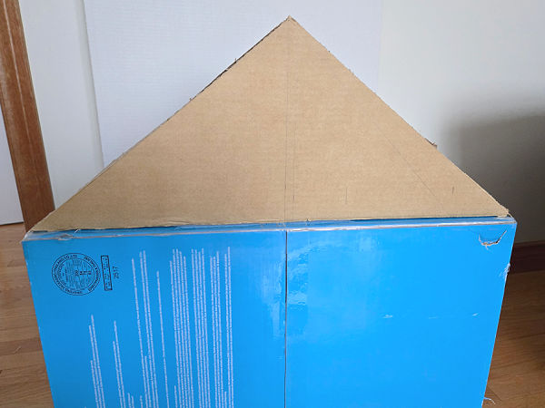 opening at back of doll house covered with cardboard