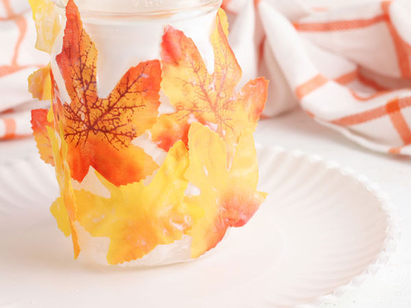 mason jar covered with fall leaves to make a lantern