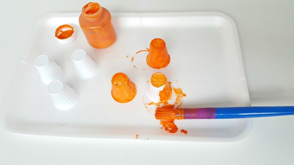 Paint recycled creamers as pumpkins