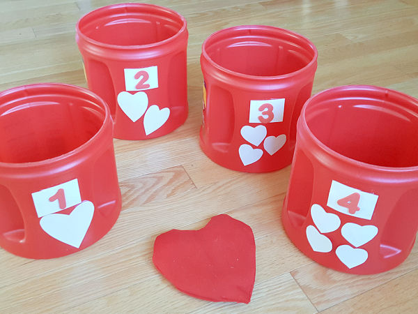 game of toss with Valentine themed containers and bean bags