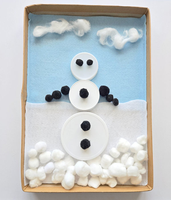 snowman made with jar lids and loose parts