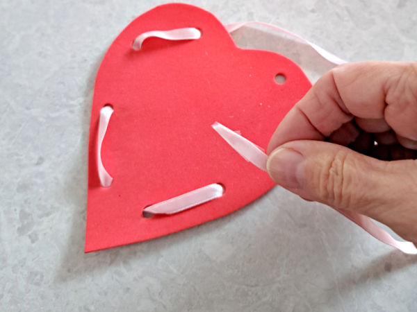 lace around the edge of the heart shape with ribbon or lace